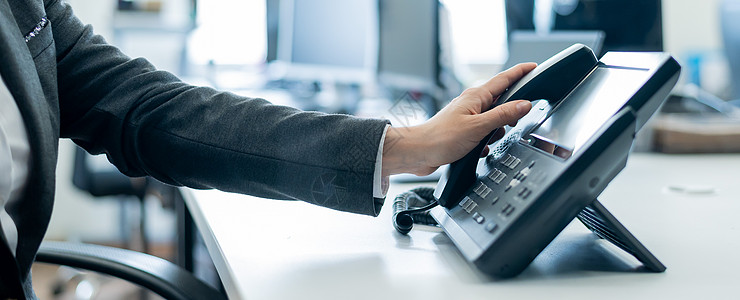 一位女员工的手放在固定电话上的特写镜头 女人在办公室的工作场所拿起按钮电话数字经理手指电讯客户桌子正装热线操作员人士图片