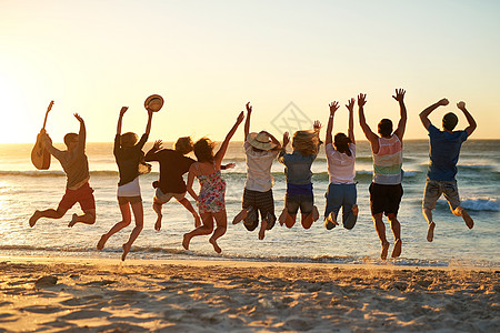 这是有史以来最棒的夏天 一群年轻朋友在沙滩上跳到空中的后视镜拍到了一阵子图片