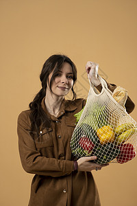 妇女展示了可再利用的网目购物袋 装满新鲜食品 零废物 生态和环境友好型包件 罐体和亚麻布 拯救自然概念图片