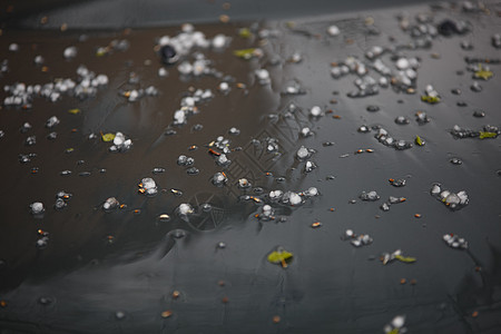 夏天暴风雨过后 黑车帽上的小冰雹冰球图片