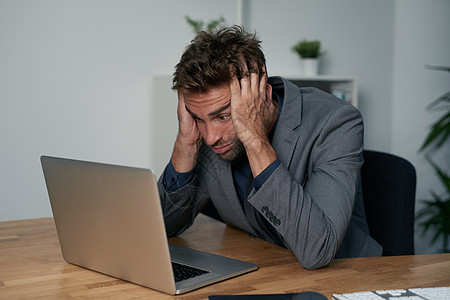 一位不知疲倦的商务人士坐在办公桌前 脸朝下地躺在手边 他受到工作压力和挫折图片
