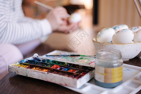 女人在幻想鸡蛋上画水彩的离焦过程 女性准备复活节彩蛋节 专注于打印表图片
