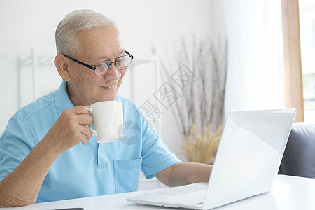 高级男子在家里使用笔记本电脑上网图片