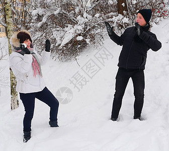 年长的母亲和少年儿女 背着雪球下雪快乐女士朋友妈妈围巾儿子季节公园女性活动图片