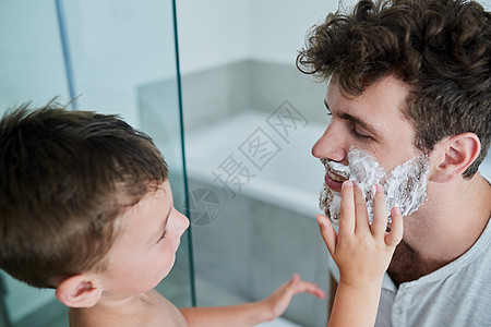 爸爸 我为你做吧 一个小男孩在家里的浴室里 父亲脸上擦刮须霜的小男孩被射中了图片