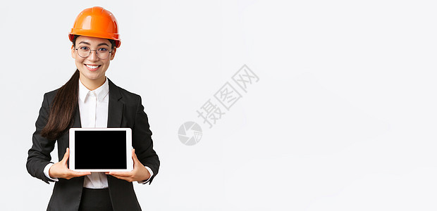 微笑的亚洲专业女建筑师介绍她的项目 工程师在数字平板电脑显示器上展示图表 在企业或工厂进行演示 站在白色背景商务经纪人建设者领导图片