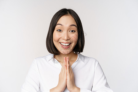 近距离的肖像 年轻日本女人展示娜玛丝特 谢谢你的阿利加图手势 站在白背景上站立手臂工作室快乐女士员工广告女孩标识技术成人图片