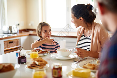 在早餐桌边玩得开心 一家人一起吃早饭的镜头男人厨房青年房子家庭关爱父母女士女孩食物图片