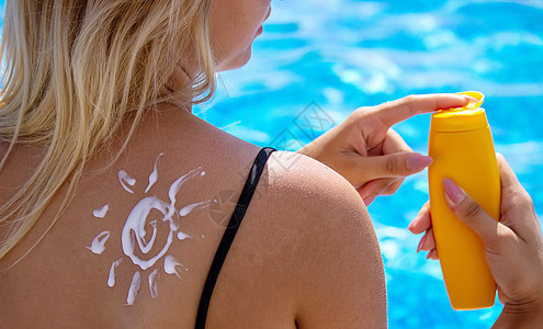女孩背上画着太阳的图画 在泳池旁边放松一下日光浴防晒霜比基尼肩膀奶油海洋身体护理皮肤棕褐色图片
