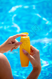 女孩背上画着太阳的图画 在泳池旁边放松一下假期皮肤科晒斑肩膀比基尼晒黑晴天护理棕褐色皮肤图片