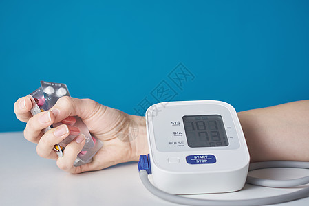 医疗护理和医药概念 与一些药片和数字血压监测器并肩工作疾病危险高血压脉冲抗生素药剂情况桌子蓝色工具图片