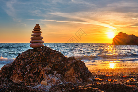 平衡与和谐的概念     海滩上的石头堆背景日落天空风水阳光团体蓝色卵石海岸冥想图片