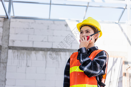 在建筑工地工作的亚洲工程师工头建筑师女工与收音机交谈验船师对讲机控制承包商项目商业挖掘机装修经理土地图片