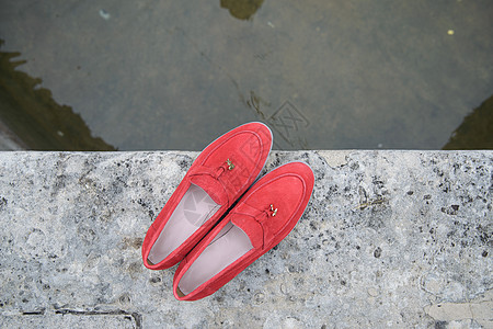 女性的红色时装衣物皮鞋在石料背景上 鲜艳的女性脱衣女鞋对等室外魅力喷泉拖鞋芭蕾舞星星衣服街道平底鞋类牛仔裤图片