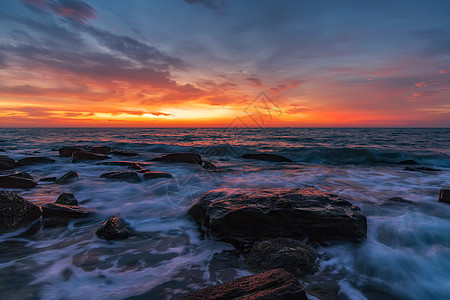 日出前在岩石上漂浮的美丽运动 模糊的海浪图片
