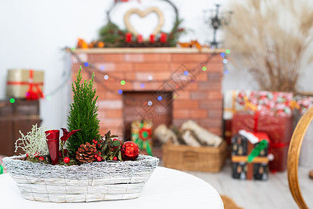 就在镜头前是一根圣诞芦苇 提醒我们正在进行的圣诞节 在背景中有一个壁炉和礼物蜡烛篮子作品季节幸福居家工艺针叶树芦苇云杉图片