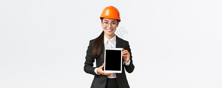 微笑的专业女工程师 女销售员或房地产经纪人向客户展示位置 站在安全头盔和商务套装中 在平板电脑屏幕上介绍建设项目建筑师电子商务团图片