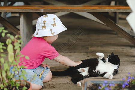 一个小女孩在户外玩逗猫 户外的孩子和她的小猫图片