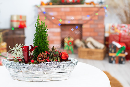 镜头前是一根圣诞芦苇 象征着即将到来的圣诞节 在背景中有一个壁炉和礼物图片