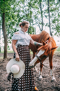 身穿白色上衣和裙子 穿着马匹 在夏日森林里女孩女士公园动物女性马术绿色乡村图片