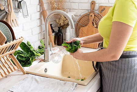 女人在厨房洗菠菜 在厨房辛克蔬菜食物自然光女性房子饮食冲洗生产洗涤美食图片