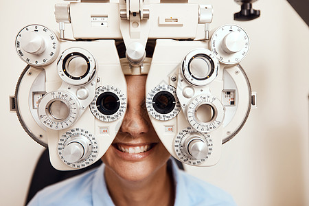 我用我的小眼睛窥探 一个年轻女人被一个光学阻击器 检查她的眼睛图片