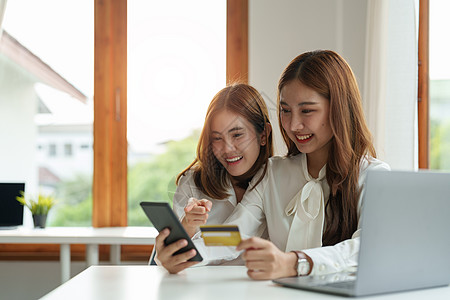 两个亚洲女友在网上购物 家里用智能电话和信用卡买手机和信用卡消费者女性安全技术店铺金融女士银行业商业购物图片