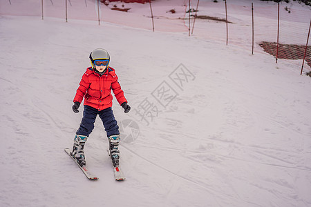 儿童在山中滑雪 带安全帽 护目镜和杆的活跃蹒跚学步的孩子 幼儿滑雪比赛 家庭的冬季运动 高山学校的孩子们滑雪课 小滑雪者在雪地里图片