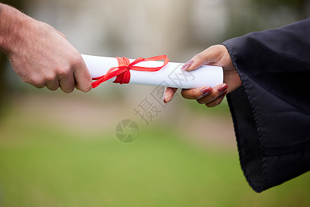 使用此令牌进一步释放您的潜力 一个面目全非的毕业生在毕业那天收到证书的特写镜头图片