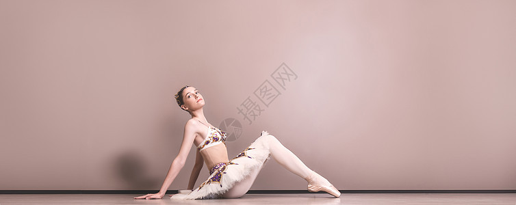 年轻漂亮优雅的白种人芭蕾舞演员穿着芭蕾舞短裙练习芭蕾舞姿势 古典芭蕾舞演员坐在芭蕾舞工作室的地板上婴儿可用身体微笑空间裙子艺术女图片