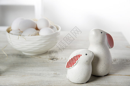 两座白兔雕像 红耳朵大 小 木锯切成两块 在斯堪的纳维亚风格的白色厨房里 一个碗和鸡蛋兔子陶器塑像陶瓷烹饪饮食制品营养食物桌子图片