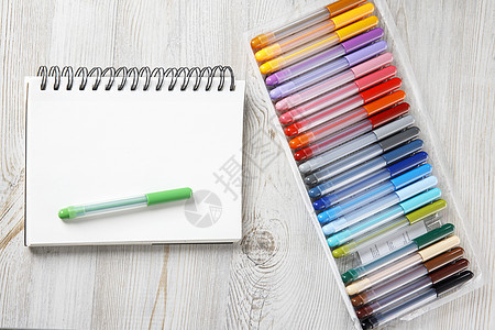 从上面查看 24个彩色标记和笔记本都在绘图桌上软垫工具毛毡教育橙子桌子毡笔记事本乐器绘画图片