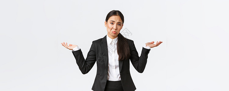 无能为力的亚洲年轻女办公室职员 身穿黑色西装的经理 耸耸肩 双手横向伸展 不知不觉地噘着嘴 不知道 无法理解 站着无用和优柔寡断图片