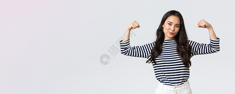 强健自信的亚洲女性柔韧性小比塞普斯 在注册体育馆会员资格之后吹嘘她的完美形状 与肌肉 运动和感觉强烈抗争 并保持体型人士学生幸福图片