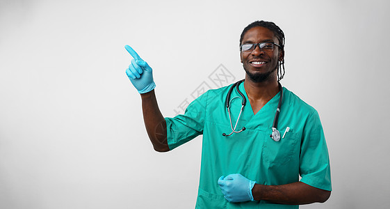 非裔美国医生用手和手指指向另一边微笑器材黑色手势药品灰色医疗用品男人皮肤图片