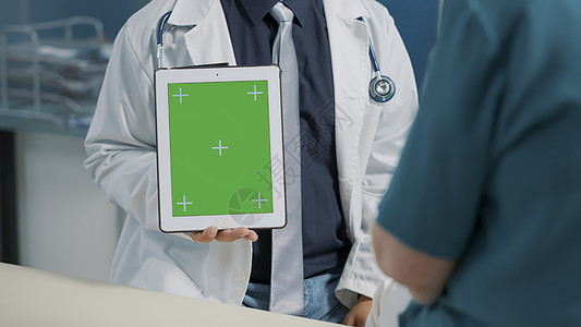 在数字平板电脑上垂直持有绿色屏幕的物理治疗师图片