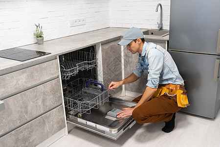 男人在厨房打开或特写洗碗机图片