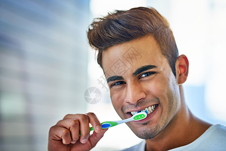 我的口腔健康取决于它 一个快乐的年轻人在家里刷牙的肖像 (笑声)图片