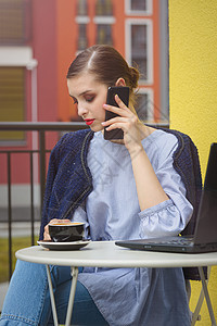 富有魅力的快乐女学生通过电话沟通 并使用笔记本电脑为课程工作做准备 请访问InfoFinland上的芬兰语和瑞典语女性学生商业桌图片