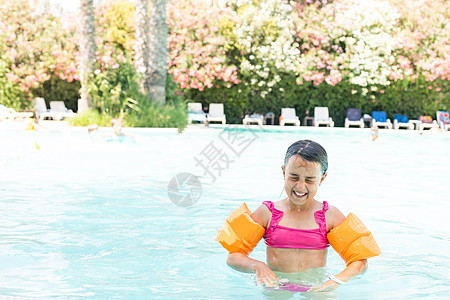 小女孩在户外游泳池玩耍孩子们潜水晴天幸福玩具水池戒指棕褐色假期女孩图片