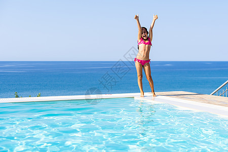 游泳池的小女孩 暑假户外喜悦游泳女孩臂章孩子乐园潜水闲暇蓝色游泳衣图片