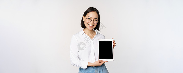 年轻女性专业人士展示数码平板屏幕 关于她小工具的信息 微笑和看着相机 站在白背景上站立的画面 掌声办公室手臂人士商务冒充快乐技术图片