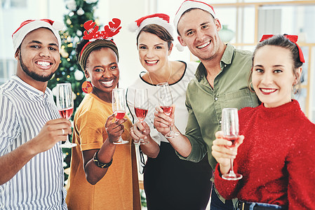 我们祝大家圣诞快乐 一群有创意的商务人士在他们的办公室圣诞派对上喝香槟和庆祝的肖像图片