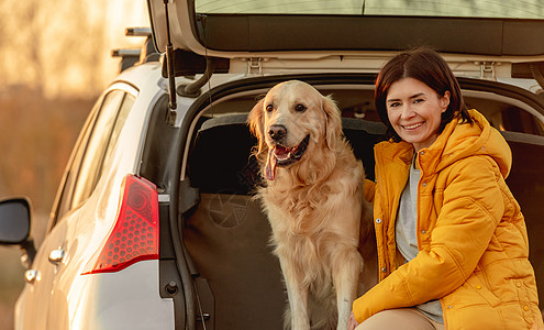 车背景图车上有金色寻金狗的女孩友谊微笑旅行女士宠物女性运输动物车辆喜悦背景