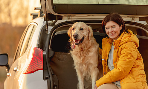 车上有金色寻金狗的女孩友谊微笑旅行女士宠物女性运输动物车辆喜悦图片