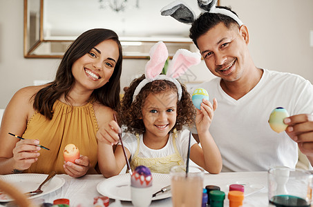 复活节是与家人一起庆祝的特殊时刻 一家人一起画复活节彩蛋的镜头图片