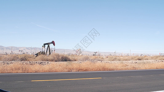 美国油田油井的泵罐 油田油井原油化石开采的里装商业管道汽油沙漠钻孔机器勘探萃取化石资源图片