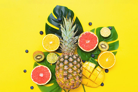 夏季海报 黄背景的棕榈树叶上的夏天果实水果和浆果图片