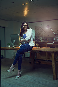 将生产力放在首位 然后是成功的 一个在办公室工作到很晚的年轻女商务人士的肖像图片