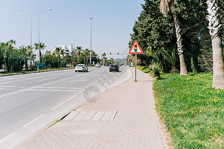 红绿灯标志站在南部城市高速公路附近的人行道上 手掌放在边线上 在繁忙的道路附近停车灯标志图片